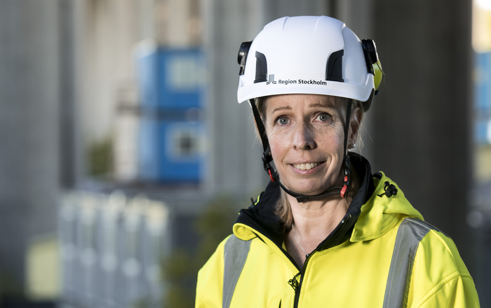 Person med vit hjälm och gul jacka.