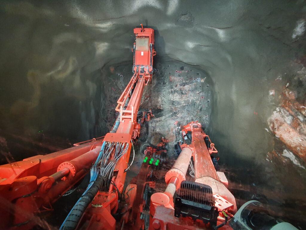 Borrning för sprängsalvor i Robothöjden. Arbete med stationsutrymme för Barkarbystaden samt spårtunnlar mot Landningsbanan (österut) och Barkarby/Veddesta (västerut). Borriggen är en Sandvik DT 1132i .