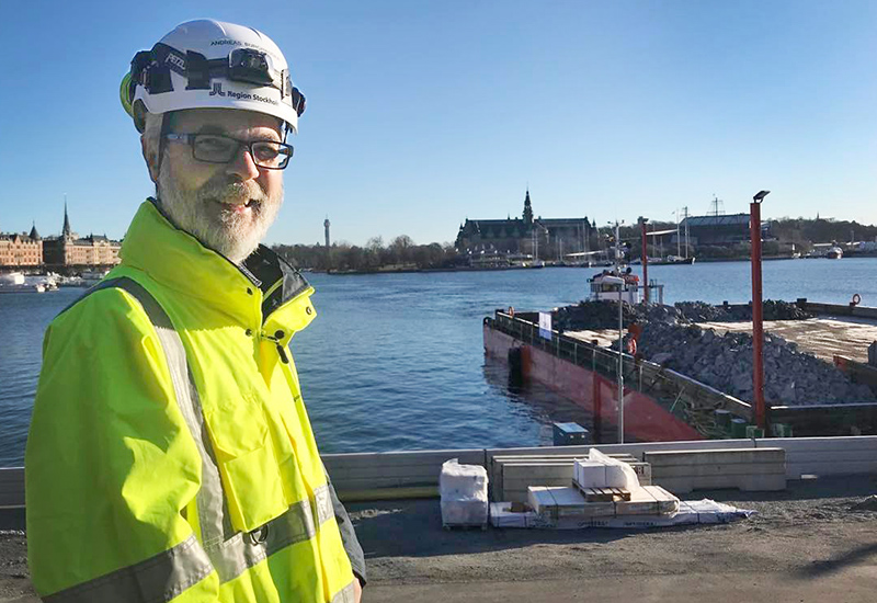 Projketchef Andreas Burghauser framför pråmen lastad med bergmassor