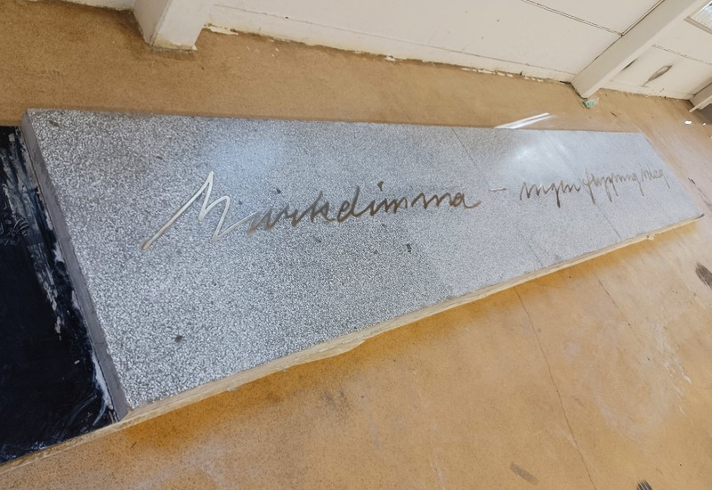 Betongkonstruktion med ingjuten text av mässing.