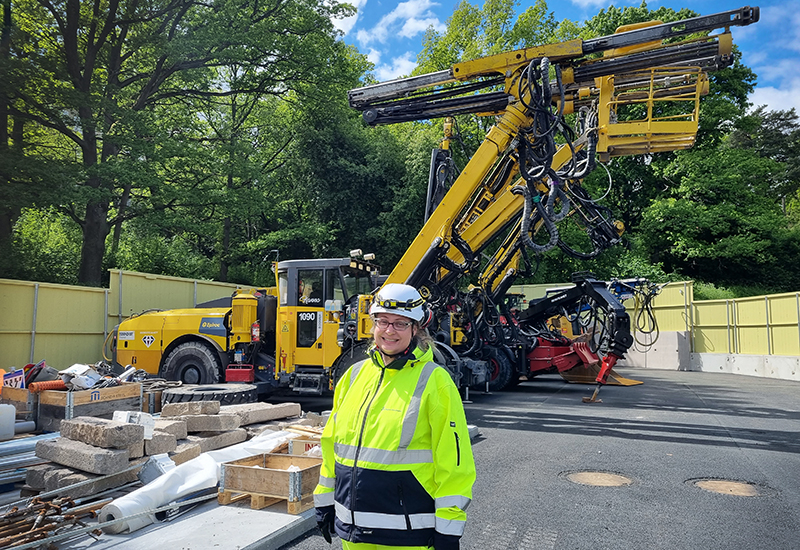 Hanna Nahlin står i gul arbetsjacka framför den stora gula borriggen.