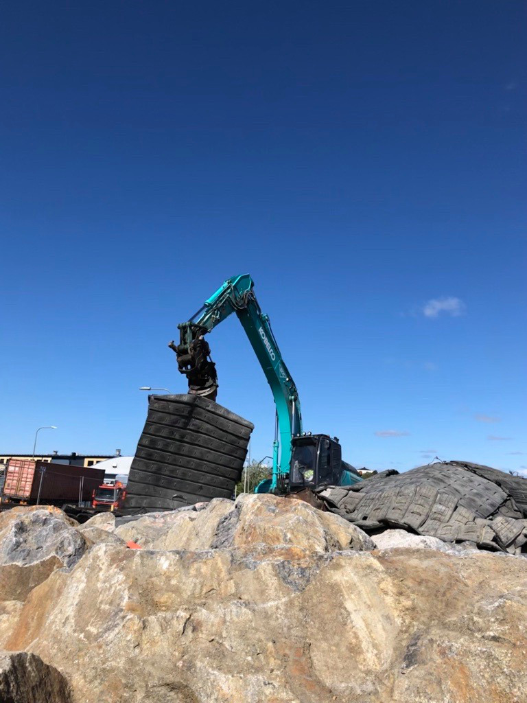 Sprängmattor lyfts på plats inför en sprängning ovan jord.