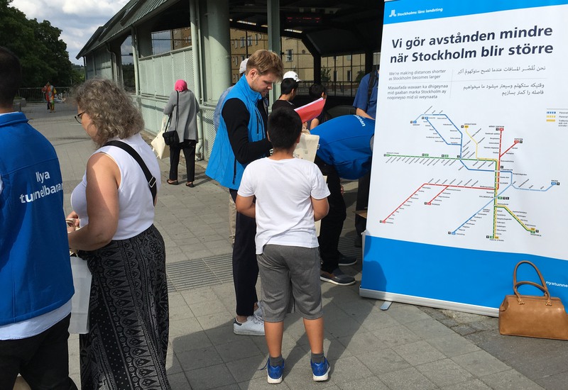 Pojke pratar om tunnelbanan med en person i blå väst