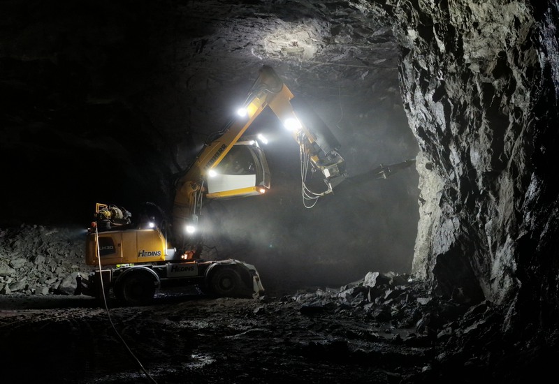 Maskiin som rensar tunnelfronten ren från lösa stenar.