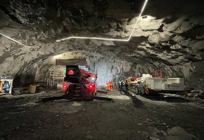 I en tunnel står två maskiner uppställda. I taket går ljusslingor i olika riktningar.