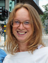 Kaisa Nugin har blont, axellångt hår och glasögon.