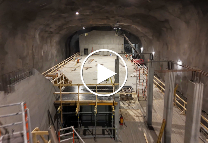 Station Sofias plattform under byggnation. En knapp för uppspelning av video mitt i bilden.