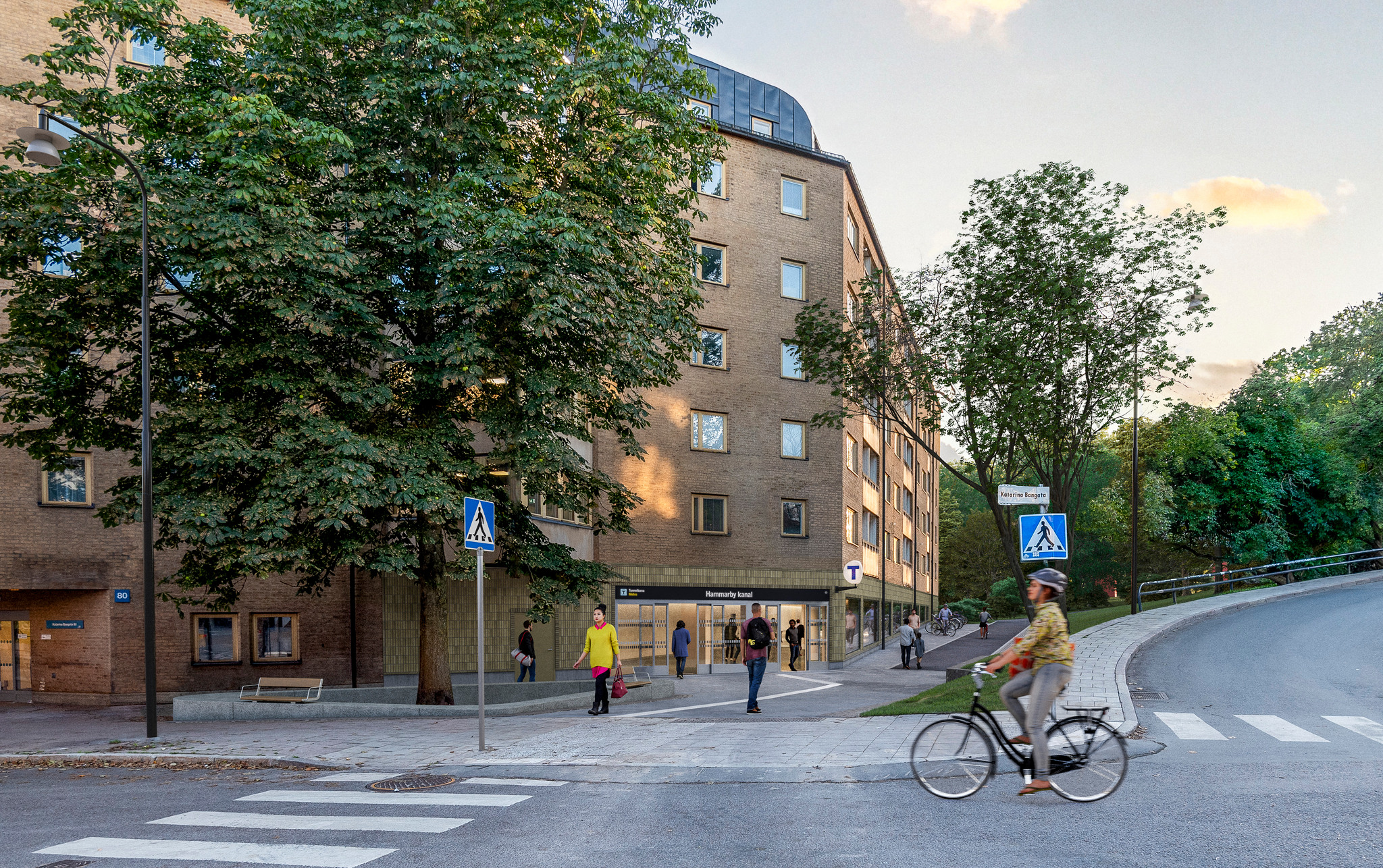 En visionsbild som visar en entré till en tunnelbanestation. Entrén ligger i ett gult hus.